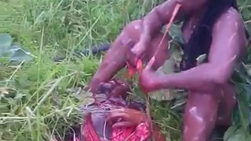 African Tribe Woman Eating Dead Man